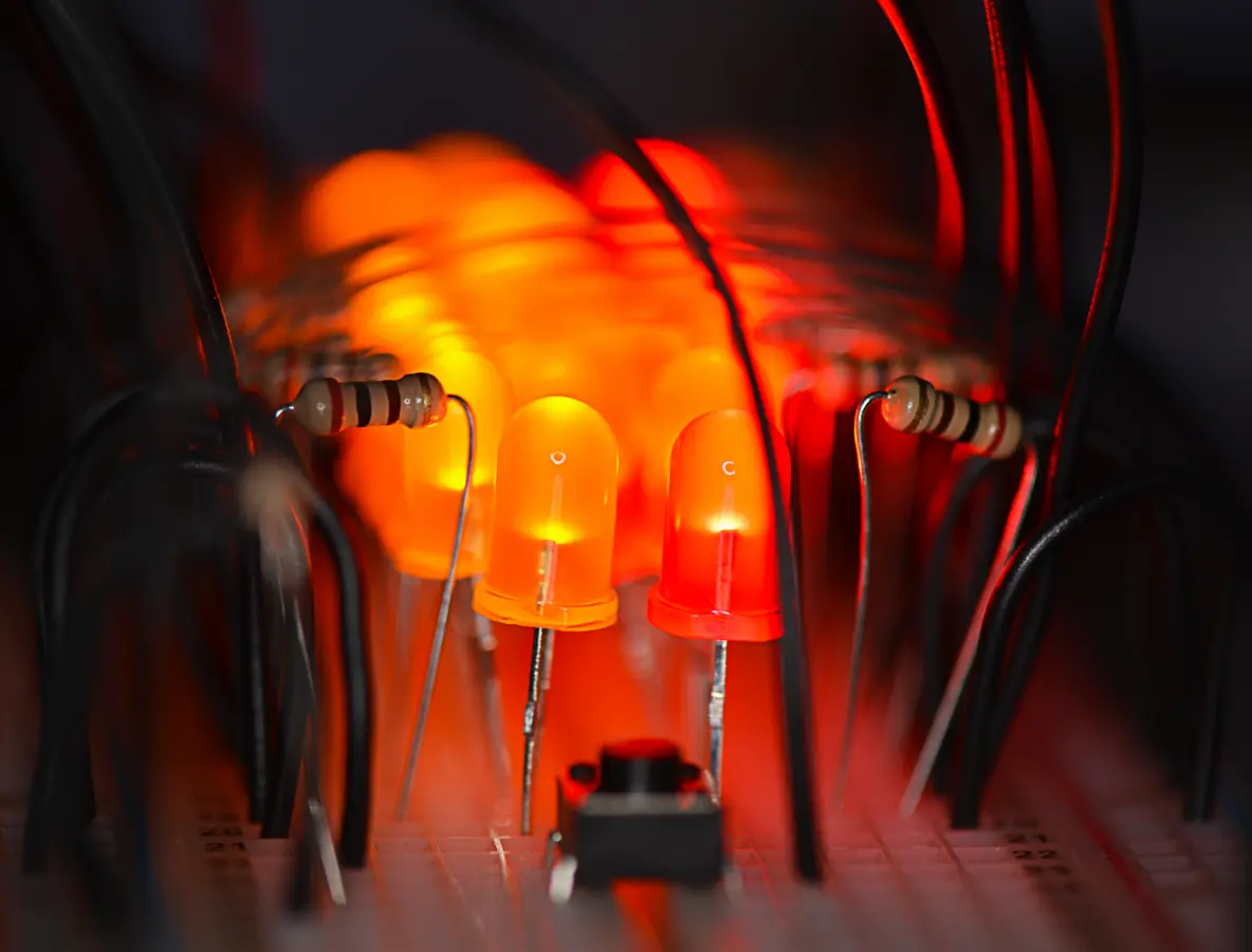Macro photograph of glowing red and amber LEDs on a circuit