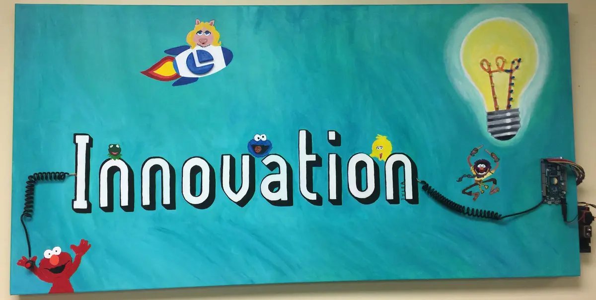 Hand-painted innovation mural with whimsical technology characters
